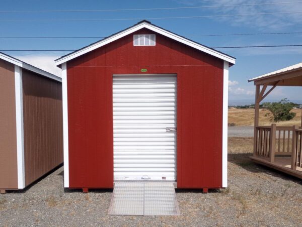 Red storage shed with white roll-up door and ramps